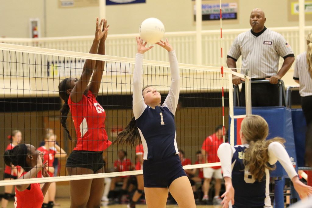 Jacksonville's Halee Holtbrooks (1) tries to avoid being blocked by Saks' Jordan Briskey during their area volleyball match Tuesday night. (Photo by Kristen Stringer/Krisp Pics Photography)