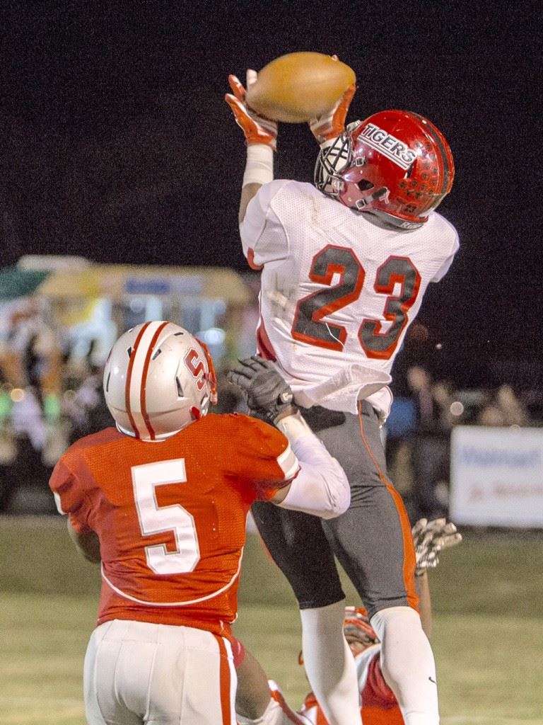 Cleburne County's Jeremiah Blake (23) goes high above Saks' Rodney Reddick to haul in a second-quarter touchdown that drew the Tigers to within 21-16 at halftime Friday. (Photo by Jonathan Fordham)