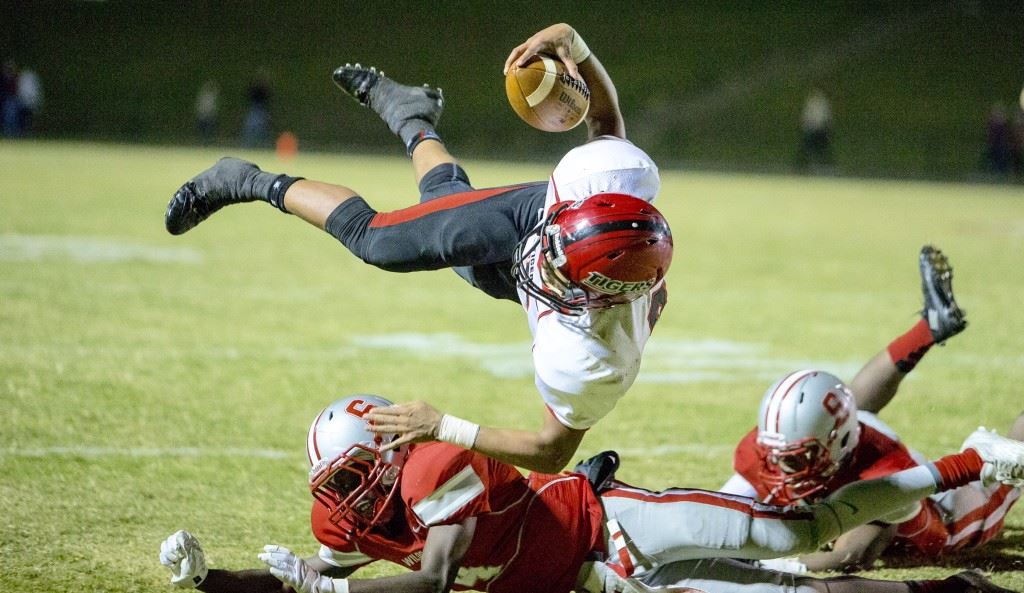 Cleburne County's Json Henson flies over Saks' Quin Smith for more yardage Friday. Henson was the Tigers' leading rusher with 166 yards. (Photo by Jonathan Fordham)