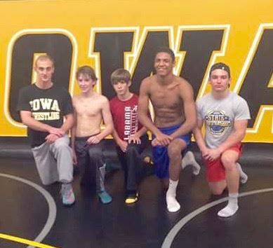 Led by coach Eric Lee (L) local wrestlers (from left) Reed Hill, Chase Hicks, Christian Knop and Josh Sexton are competing in the Conflict at Carver today at the University of Iowa. On the cover, the wrestlers work out in the Hawkeyes' practice facility. 