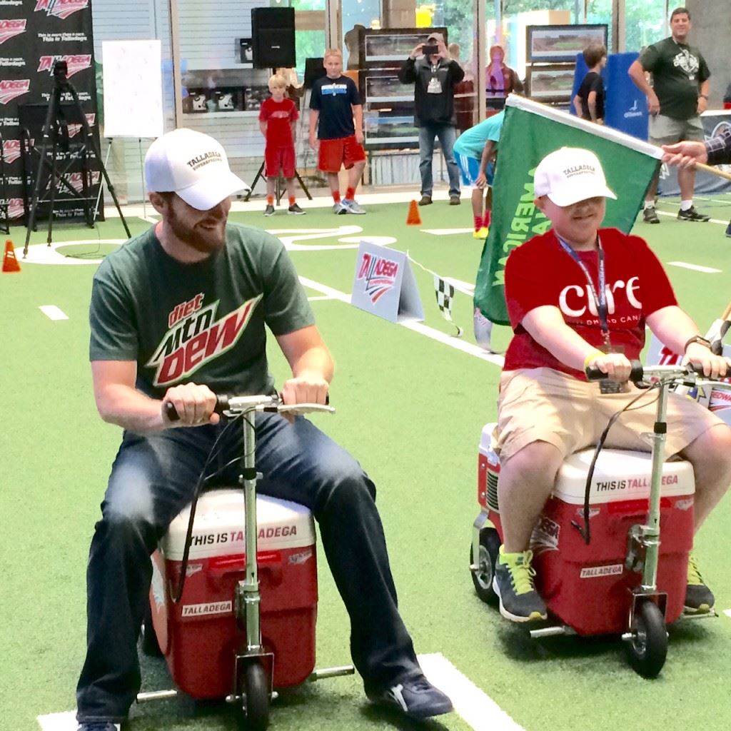 Dale Earnhardt Jr. (L) races sixth-grader Austin Freeman during a promotional appearance at the College Football Hall of Fame. Freeman, a pediatric bone cancer patient, fulfilled a dream by spending the day with his favorite driver.