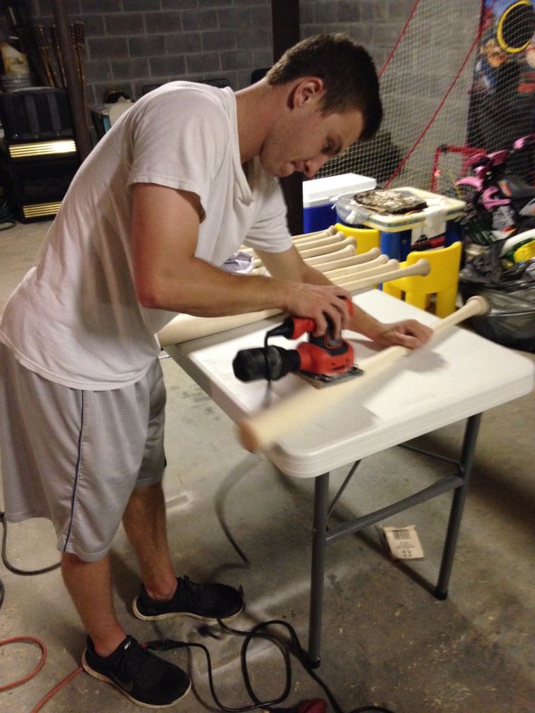 Cade Gossett smooths out the rough spots on a bat that's almost ready for finishing.