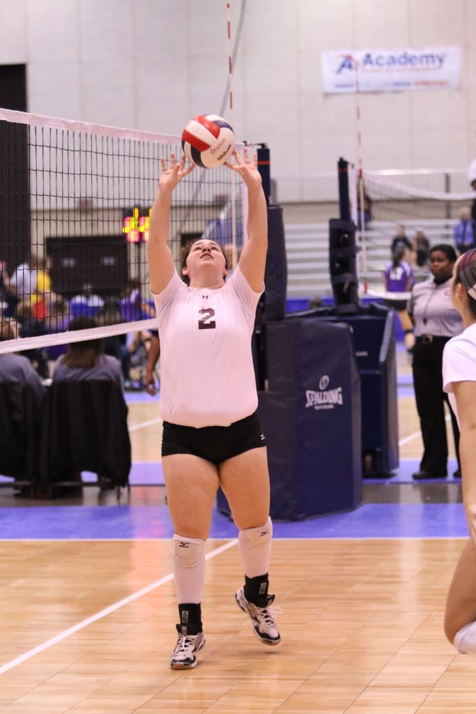 Donoho's Katie Brown sets up one of her 32 assists in the region title match against Meek. On the cover, the Donoho players rush the floor after clinching the title. (Photo by Kristen Stringer/Krisp Pics Photography)