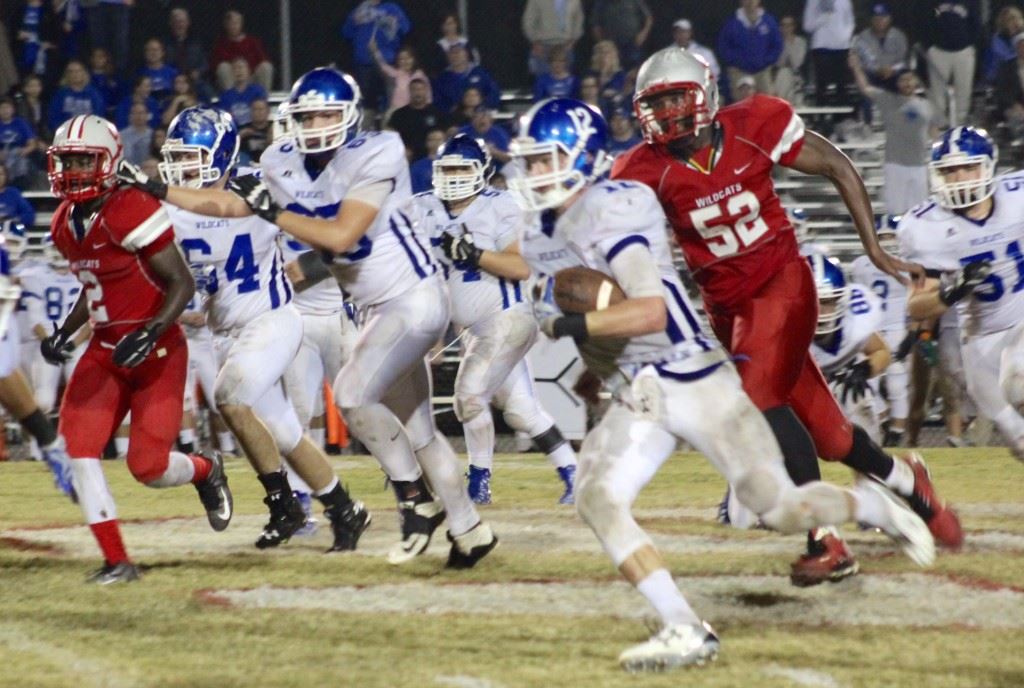 West Limestone quarterback Reed Blankenship runs for yardage as Saks' Demario Burnett (52) tries to chase him down. On the cover Blankenship is trying to escape the grasp of a Saks tackler. (Photos by Ocala Honeycutt)