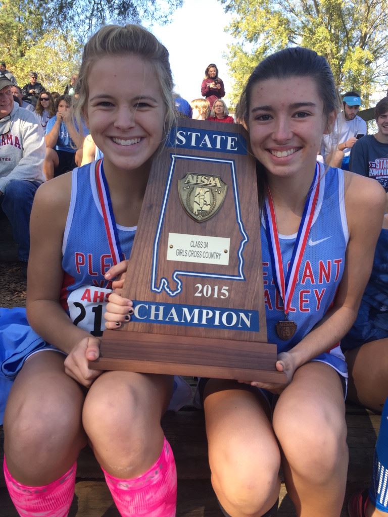 Pleasant Valley's first two finishers, Emma Hood (L) and Juliana Ballew, sit with the state championship trophy. (Photo courtesy of Tara Hood)