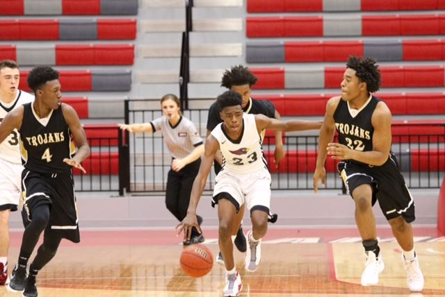 Sacred Heart's Kevion Nolan (23) races up the floor between Carrollton's Jarel Spear (4) and Dylan Parham Saturday. (Photo by Kristen Stringer/Krisp Pics Photography)