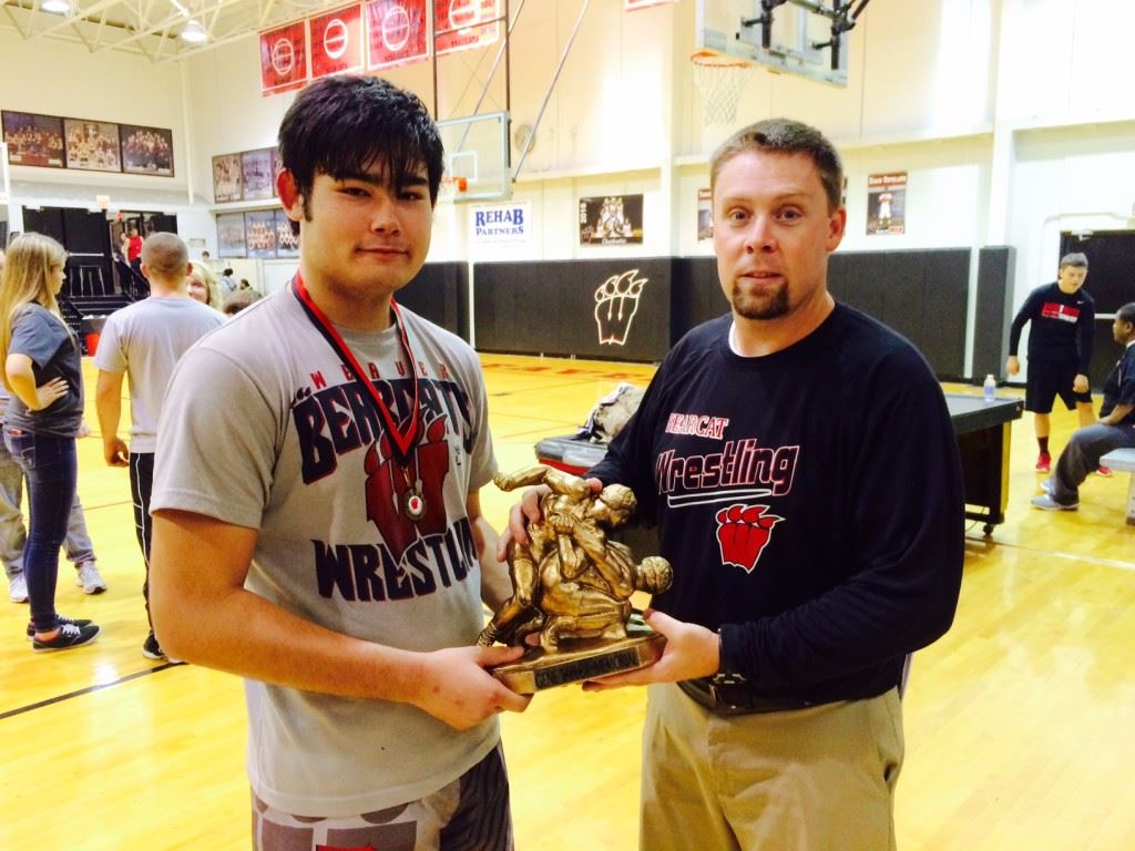 Chase Rodgers (L) and Weaver wrestling coach Andy Fulmer hold the championship trophy for the Gene Taylor Classic. Rodgers' win at 195 clinched the title for the Bearcats. 