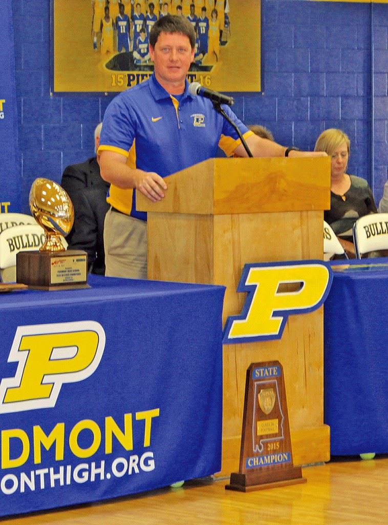 Piedmont coach Steve Smith talks proudly about the accomplishments of this year's Class 3A state championship football team. On the cover, Piedmont mayor Bill Baker displays the marker that proclaims the Bulldogs' two state titles. Below, the Piedmont seniors who helped make this season possible. (Photos by Shannon Fagan/Cherokee County Herald)