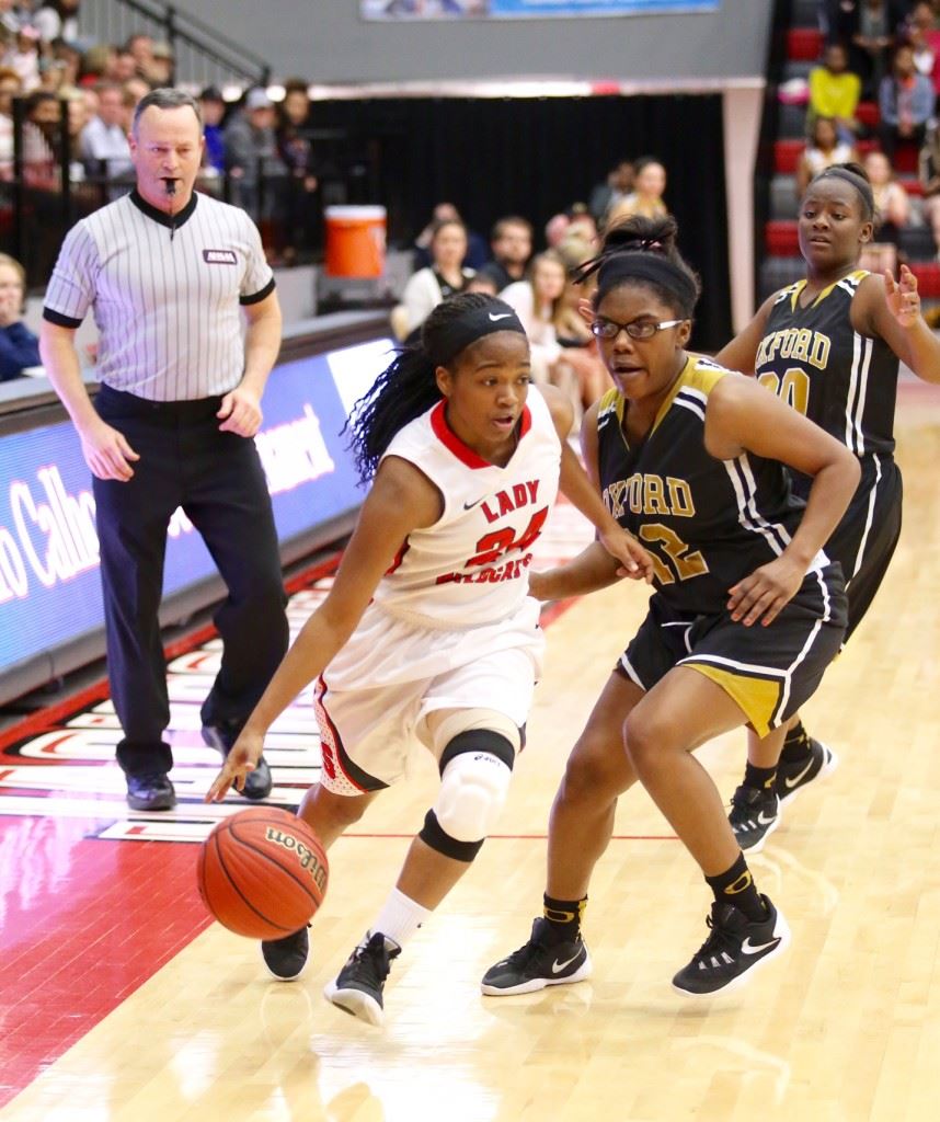 Girls MVP Daja Johnson (24) drives past Oxford's Kayla Lowery during Saturday's championship game. On the cover, the Lady Wildcats rush to collect the winner's trophy. Below, Jordan Briskey (10) prepares to attack the basket while avoiding Oxford's Makayla Kidd (3). (Photos by Kristen Stringer/Krisp Pics Photography) 