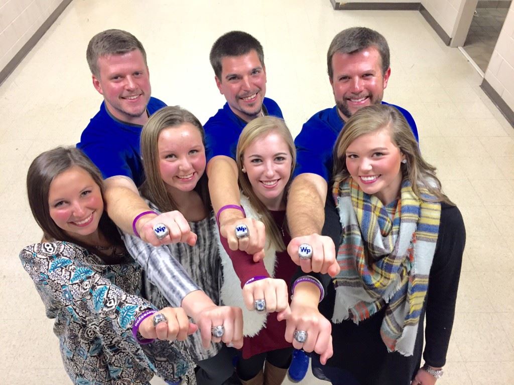 White Plains golf coach Marcus Harrell (second right), his assistant and players show off the state championship rings they had presented Tuesday night. 