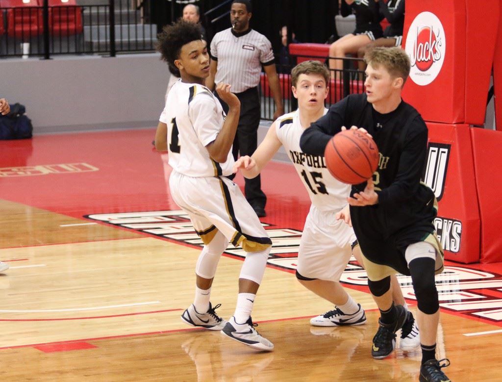 Faith Christian's Caleb McCord (R) looks to leave Oxford's Torry Robertson (1) and Andrew Pratt behind as he tries to start the break Monday. (Photo by Kristen Stringer/Krisp Pics Photography)