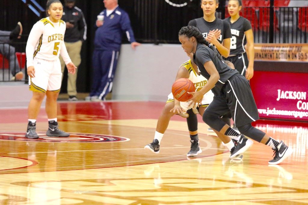 Wellborn's Vanessa Carter drives the line as Oxford's Winter Taylor (5) stands poised to slide over to defend. Taylor and Carter waged their own personal scoring war Monday in the Lady Jackets' close victory. (Photo by Kristen Stringer/Krisp Pics Photography)