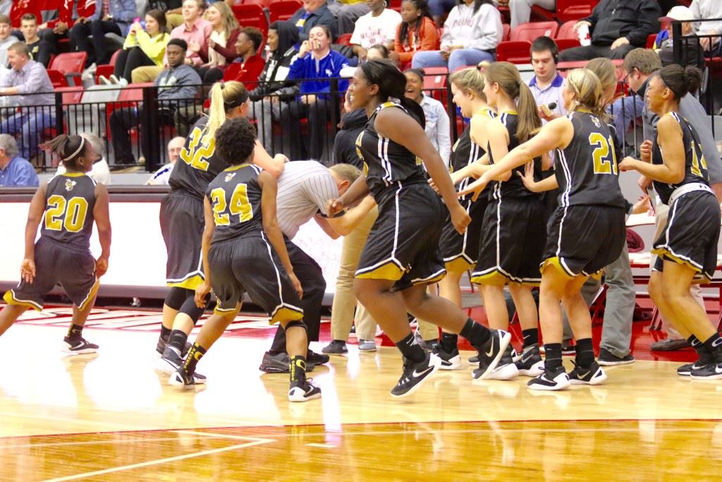 The game official is forced to duck and cover to avoid the Oxford team erupting from the bench celebrating its victory over top-seeded Anniston in overtime. (Photos by Kristen Stringer/Krisp Pics Photography