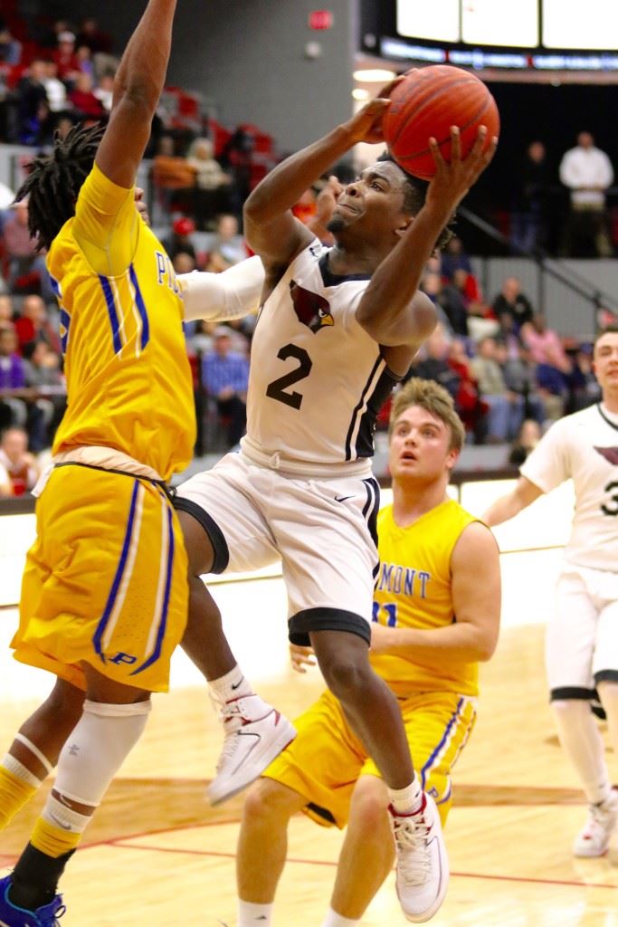 Sacred Heart's Kavarri Ross (2) tries to make a midair adjustment to get around Piedmont's Darnell Jackson. Ross scored all 12 of his points in the second half Wednesday. (Photo by Kristen Stringer/Krisp Pics Photography)