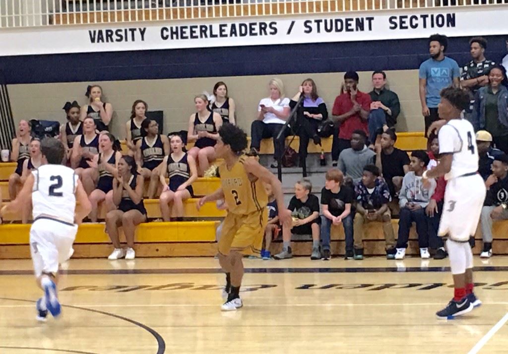 Oxford defensive specialist Jalen Moore (gold 2) was always keenly aware of where Jacksonville's Cam Horton (4) was on the floor Monday night.