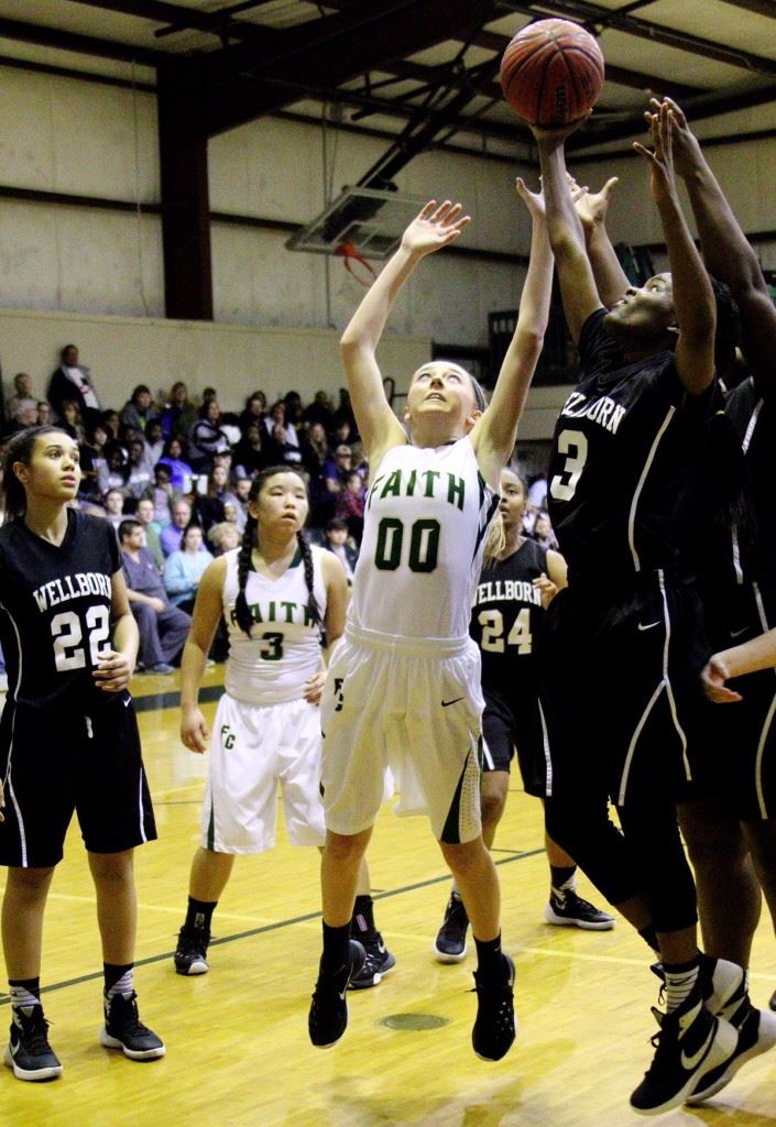 Faith Christian's Logan Boyd (00) battles with Wellborn's Vanessa Carter for a rebound during their game Friday night. (Photo by Carey Jenkins)