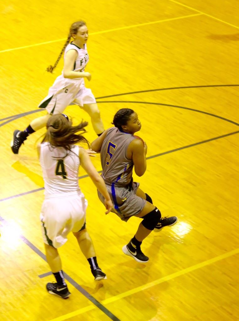 TCC's Savona Garrett (5) drives the lane for two of her 25 second-half points in Monday night's Class 1A subregional game at Faith Christian. Below, Faith's Madison Stephens (4) finished her high school career with 1,666 points. On the cover, Emily Sills passes the ball inside. (Photos by Kristen Stringer/Krisp Pics Photography)