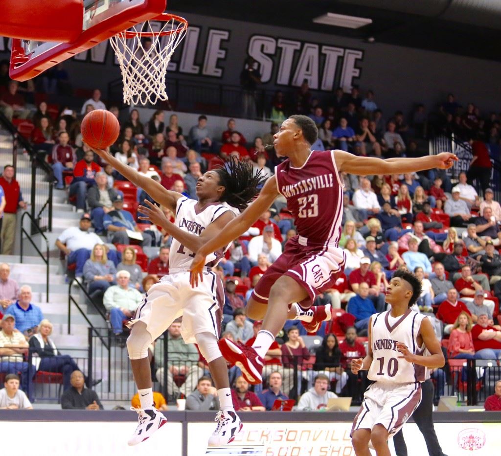 Hakeem Ross (11) drives past Guntersville's C.J. Williamson for two of the 17 points he scored off the bench Friday. On the cover, Tray Croft scored 19 of his 31 in the final six minutes to key Anniston's regional semifinal victory. (Photos by Kristen Stringer/Krisp Pics Photography) 