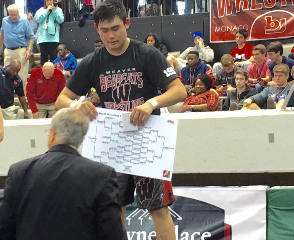 Weaver senior Chase Rodgers accepts a copy of the Class 1A-5A 195-pound bracket he won from AHSAA executive director Steve Savarese.