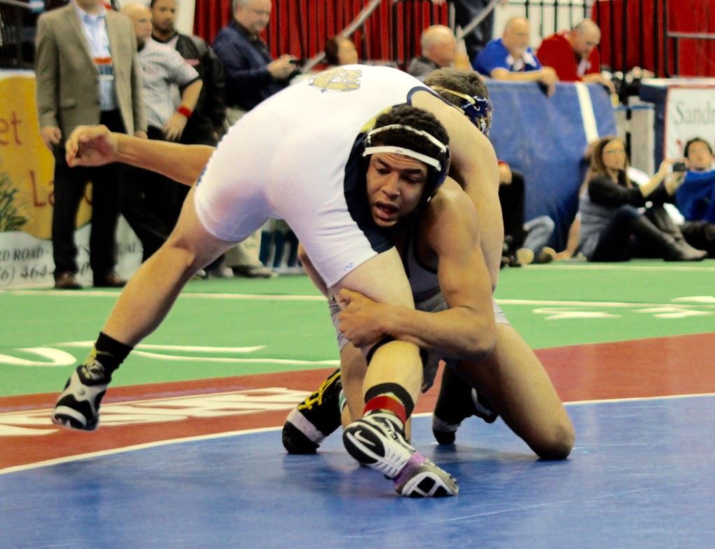 Alexandria freshman Christian Knop (R) tries to maneuver around Dora's Caleb Lauderdale during their epic 170 state championship match Saturday. On the cover, Knop leaps into the arms of Valley Cubs assistant Tyler Causey after winning the state title. (Photos courtesy of Angela Trapp)