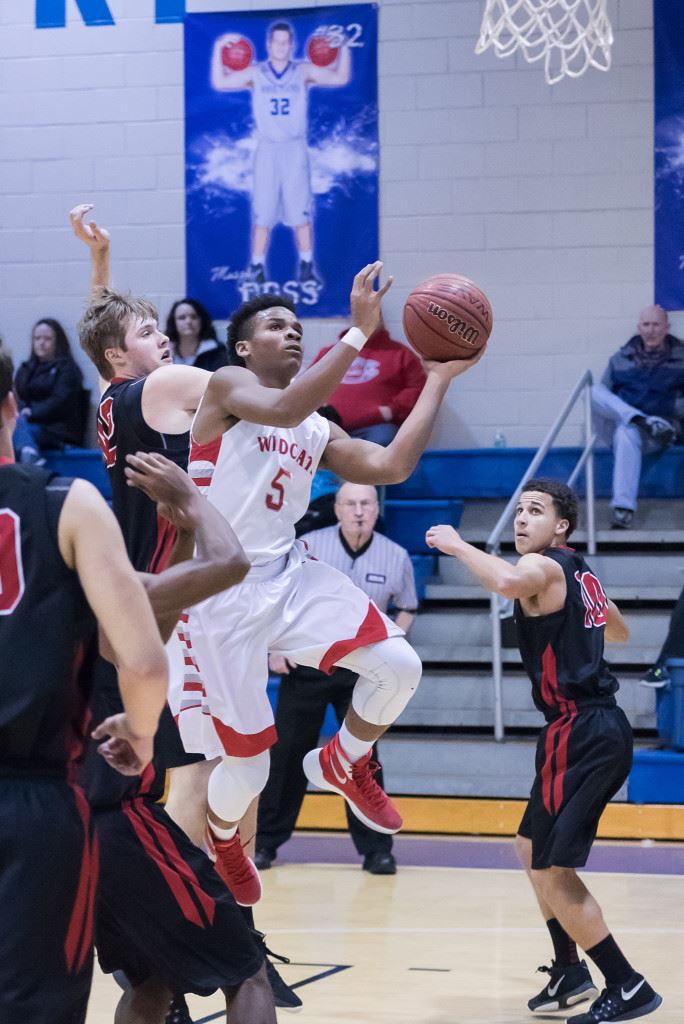 Saks' Jaylen Britt works his way through traffic to get to the basket. On the cover, Demetrius Powell dribbles past two Cleburne County defenders. (Photos by Stephen Miller)