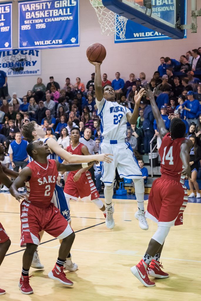 White Plains' Lawrence Jackson finds an opening in the Saks defense to put up a shot Thursday night. On the cover, Eli Hightower takes a defensive stance. (Photos by Stephen Miller)