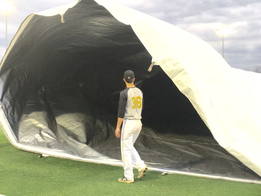 County baseball tournament MVP Andy Hammond holds on to his end as the Yellow Jackets learn to roll out the new tarp for the signature baseball field at Choccolocco Park.