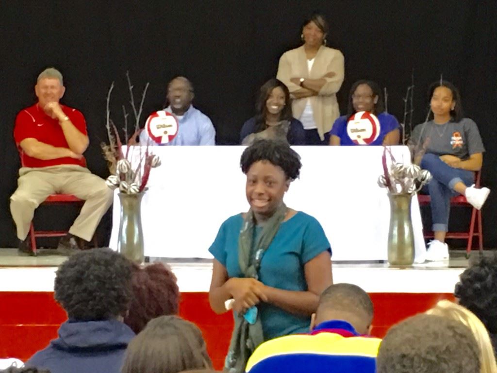 Destinee Briskey, the Donoho assistant coach and former Saks player, tells a story about her sister Jordan (center table) during the current Saks senior's signing ceremony with Southern Union.