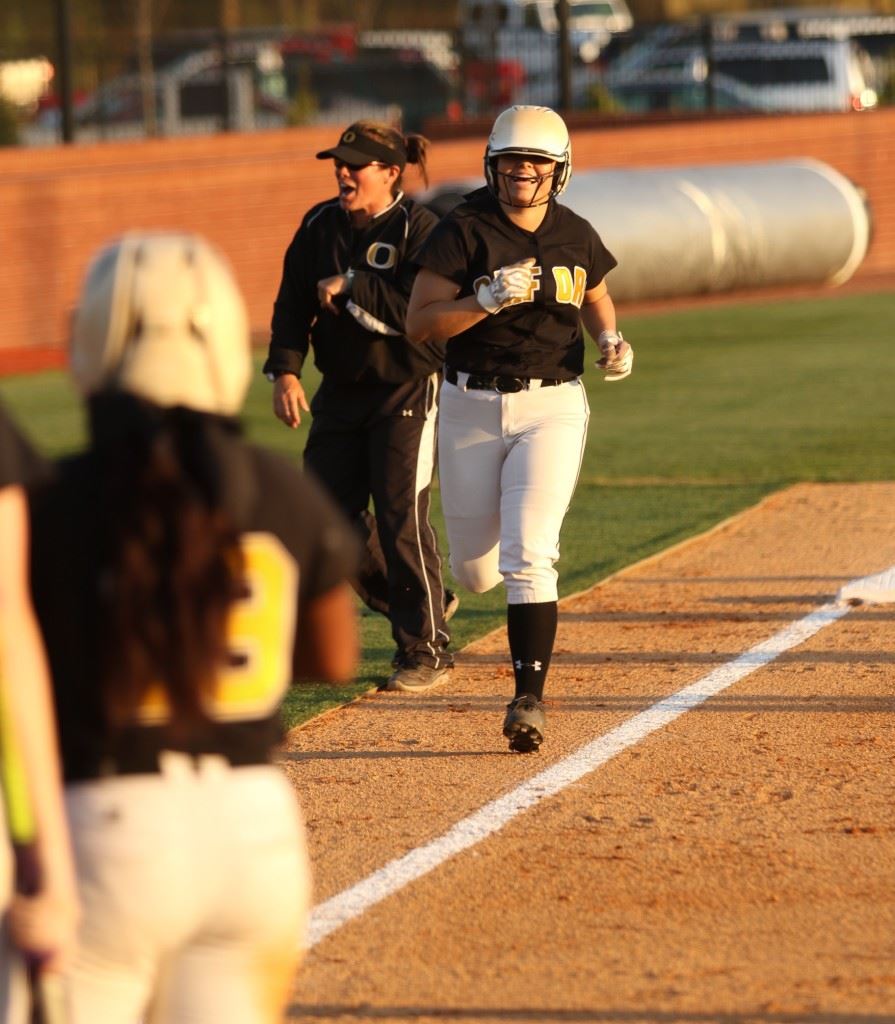 Grace Mitchell heads for home, where her teammates await, after hitting the go-ahead three-run homer in the sixth inning. It was the Lady Jackets' first homer in the new Choccolocco Park softball field. (Photo by Kristen Stringer/Krisp Pics Photography)