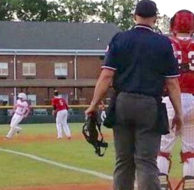 The view between the umpire's arm and body shows Westbrook's Kyle Edwards climbing the left-field fence to rob Ohatchee's Michael Cherry of a two-run game-tying homer and end the game. (Photo courtesy of Blake Jennings)