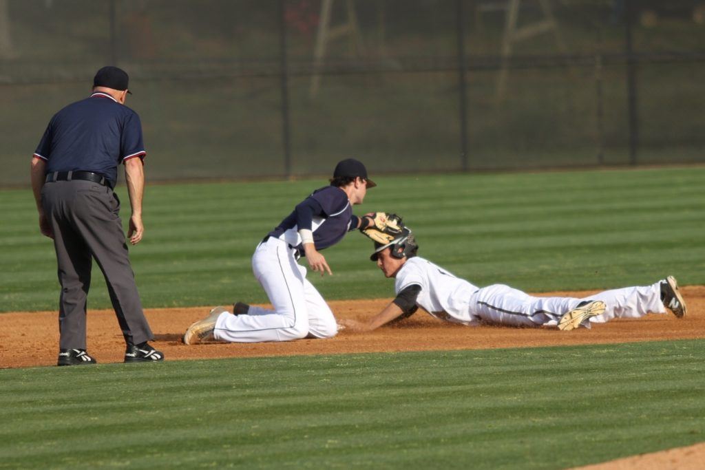 Oxford's Judd Moore slides into second as the Yellow Jackets show their aggressiveness on the base paths against Briarwood Christian. Below, Oxford coach Wes Brooks goes over a few things with first-game starter Brody Syer. (Photos by Kristen Stringer/Krisp Pics Photography)