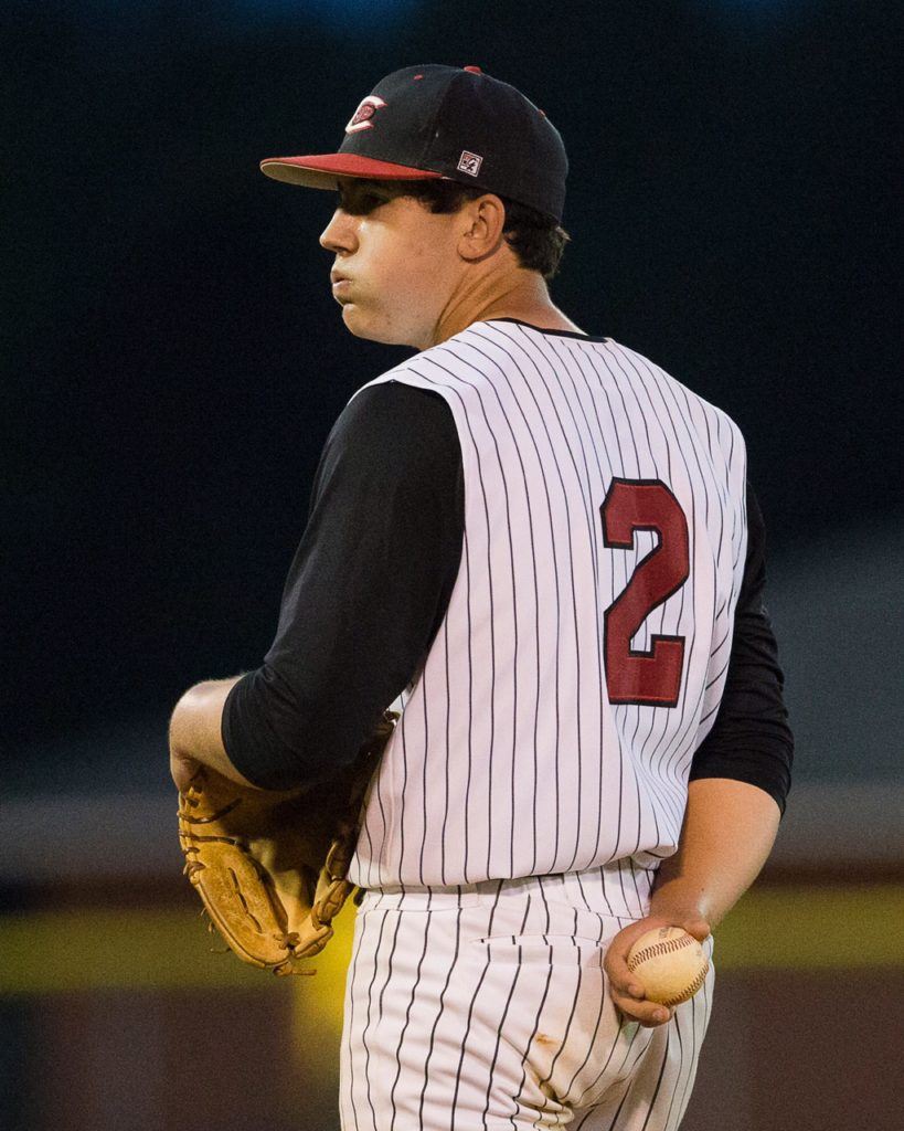 Jordan Brown looks in for a sign during the second game of Cleburne County's playoff doubleheader with Hokes Bluff Friday. Below, catcher Austin Harler prepares to fire on a runner. On the cover, Will Morrow slides head-long into home plate. (Photos by Jonathan Fordham/J&E Art&Design)