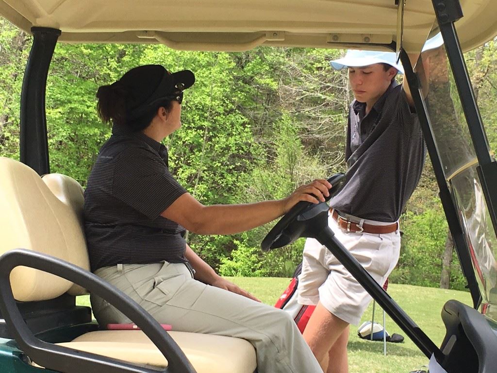 Westbrook Christian's John Hilliard Catanzaro (R) gets some advice from coach Misti Fairchild as they wait for the 15th fairway to clear Tuesday. On the cover, Hewitt-Trussville displays another winner's trophy from the Oxford-Gadsden Invitational.