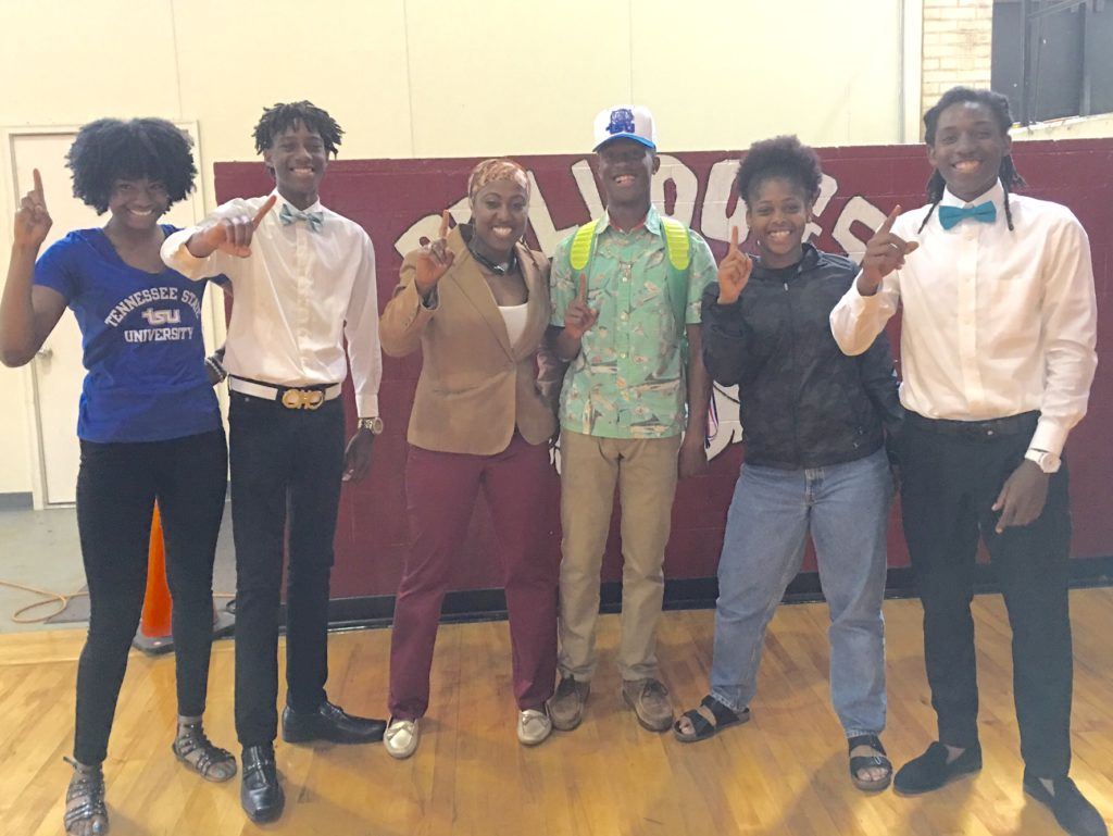 Anniston track coach Lisa Howard (third from left) stands with the five Bulldogs who signed college scholarship letters Monday.