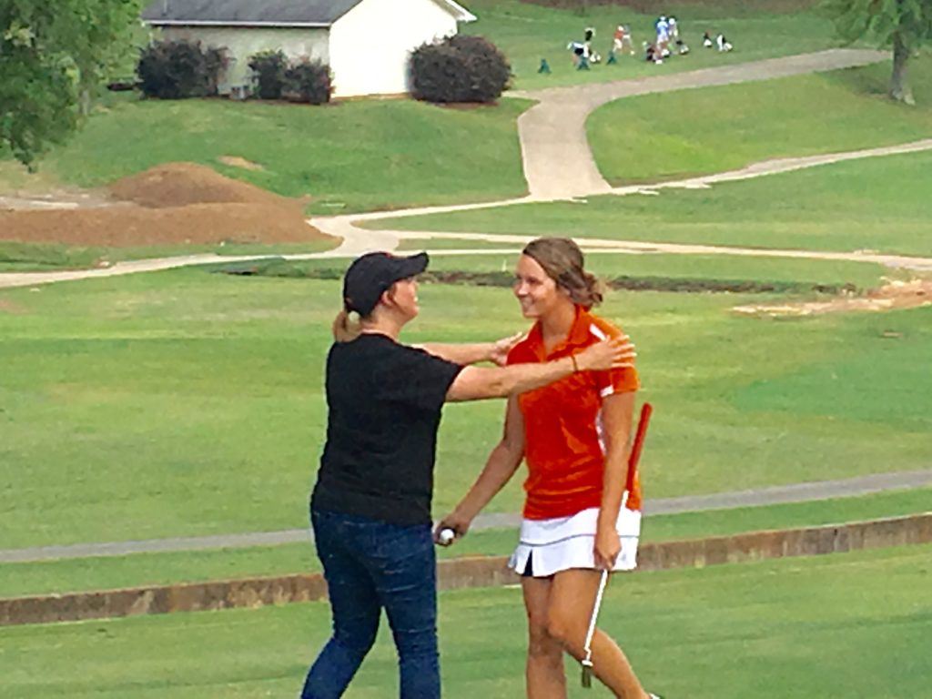 Alexandria's Abby Stevens is greeted by her mother after sinking a long birdie putt in a playoff to earn a spot in the state tournament.