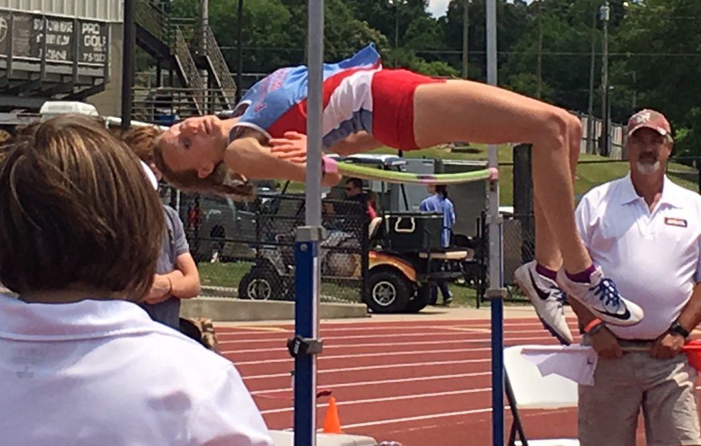 Pleasant Valley's Rachel Faucett clears the bar at 5-2 on her way to a third straight state high jump title. Below, she reviews the video of her winning jump.