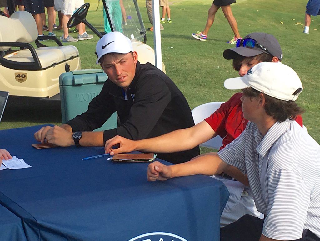 White Plains' Layton Bussey (L) talks with his playing partners after Tuesday's final round of the state tournament. On the cover, Bussey (R) and Andrew Graves of UMS-Wright shared low medalist.