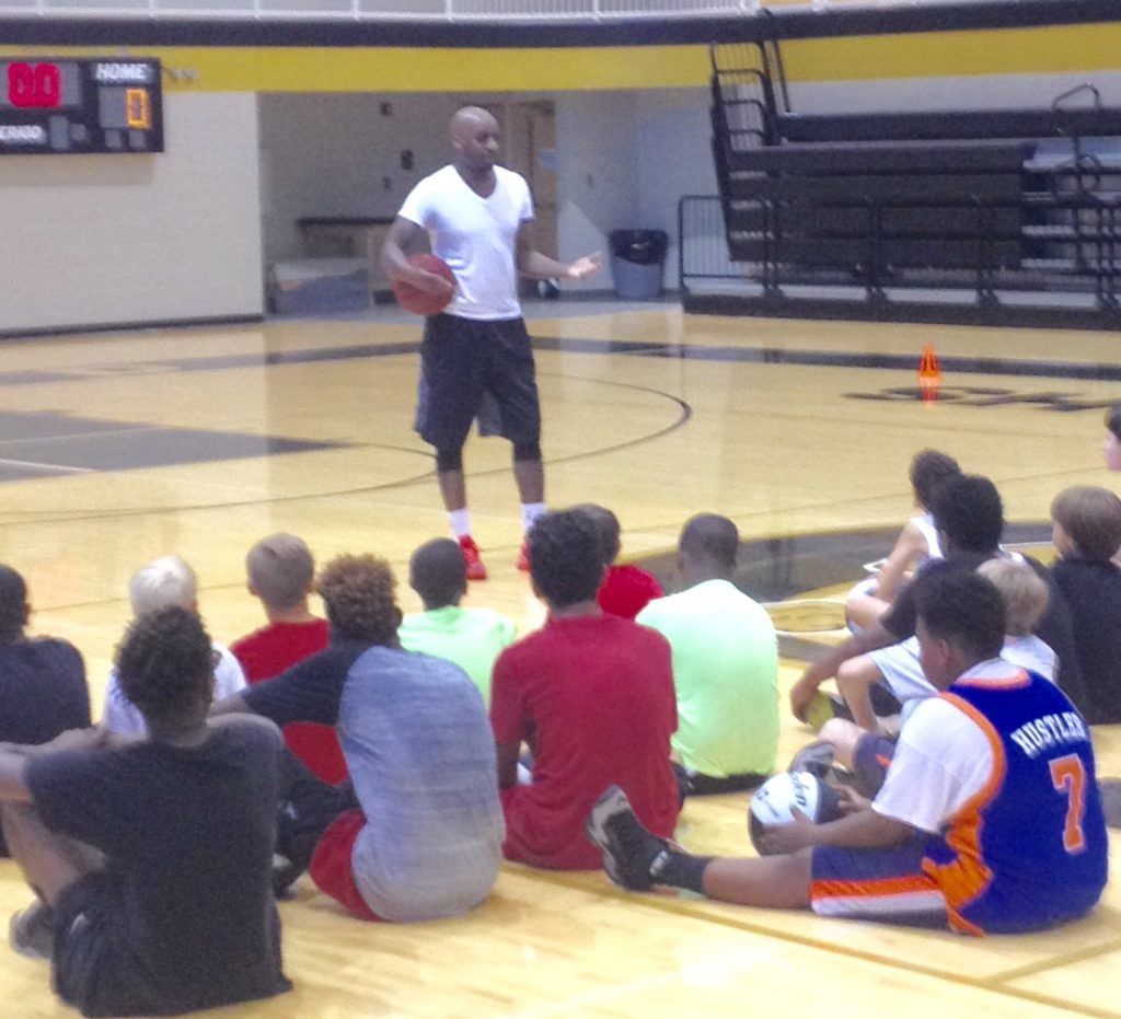 Former NBA point guard Walker D. Russell talks to the campers at the conclusion of Oxford's fifth annual basketball camp Friday.