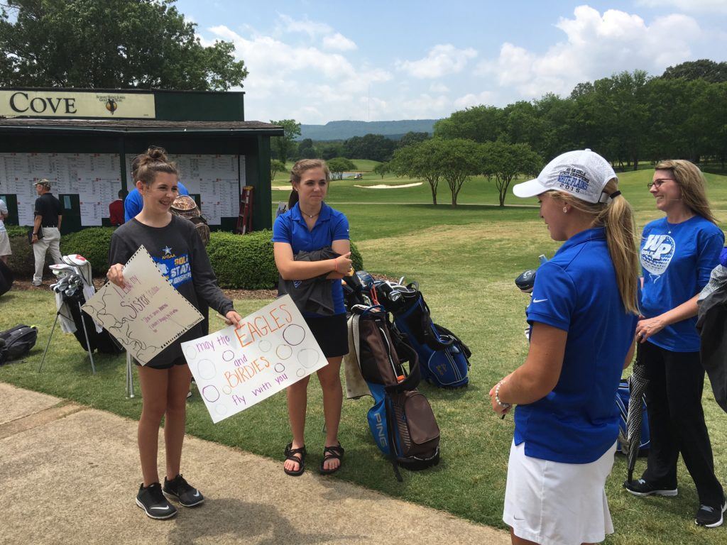 White Plains senior Morgan Prickett checks out the posters her family made after her final high school round in the state tournament Tuesday. 