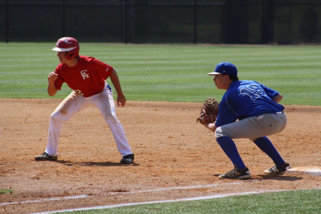 Excel Blue Sox first baseman Ethan Whitley (18) is poised to catch CABA's Tyler Carter off-guard in Sunday's 16U championship game. (Photo by Connie Green)