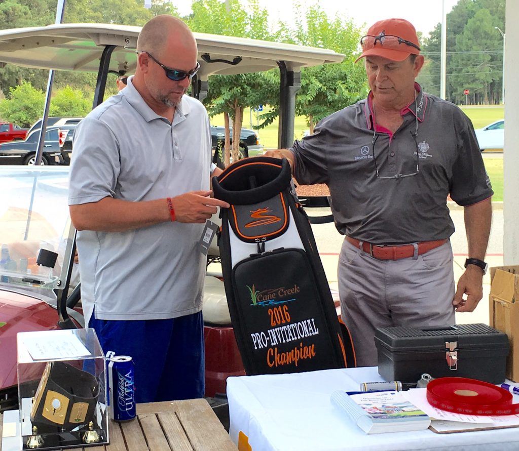 Medalist Ty Cole (L) checks out the golf bag presented by Cane Creek pro Kenny Szuch for winning the flight winners playoff in the Pro-Invitational Sunday. 