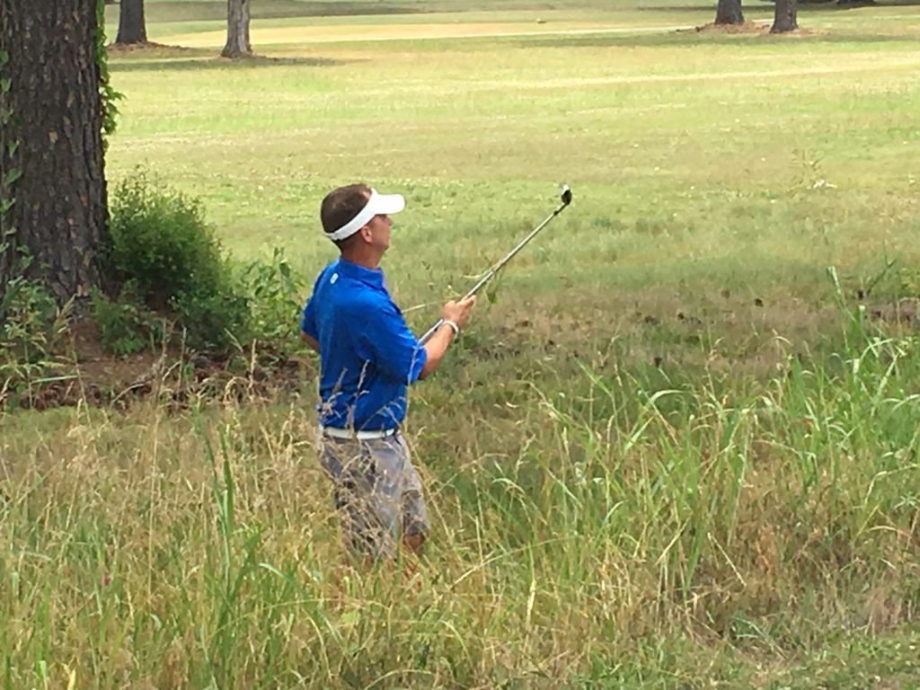 Jeremy McGatha follows the flight of his first shot out of the tall grass on 14 Saturday at Cane Creek. Despite finding hazards twice on the hole, McGatha made par.