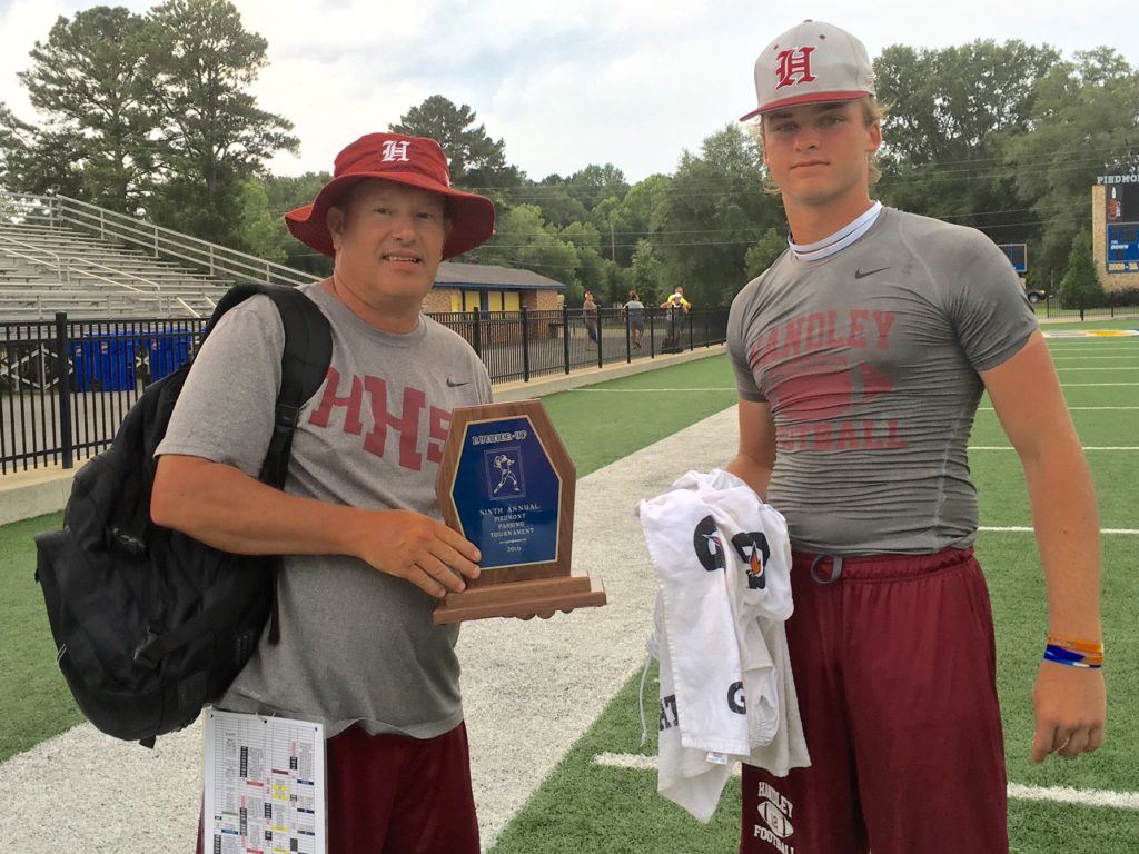 Handley coach Larry Strain (L) and senior quarterback Rhett Fetner leave the field together after playing host Piedmont in the championship game of the Bulldogs' 7-on-7 tournament Saturday.