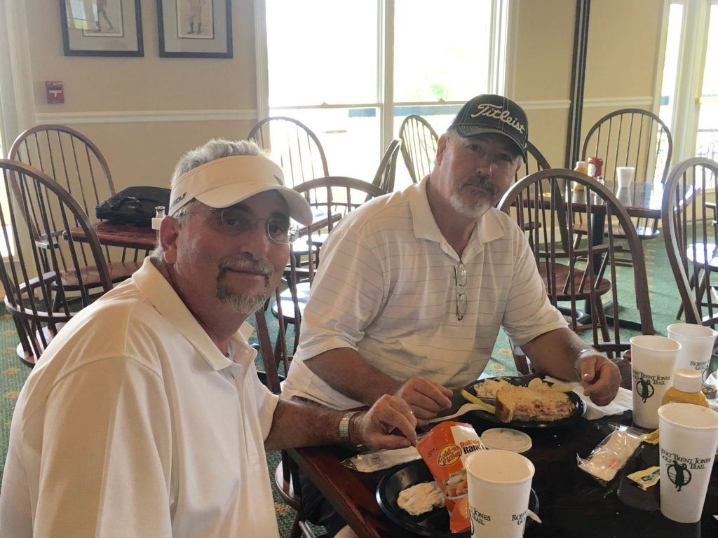 Bruce Collins (L) and Charles Estes enjoy a little lunch after being the first team to post 14-under-par 58 at Silver Lakes Friday.