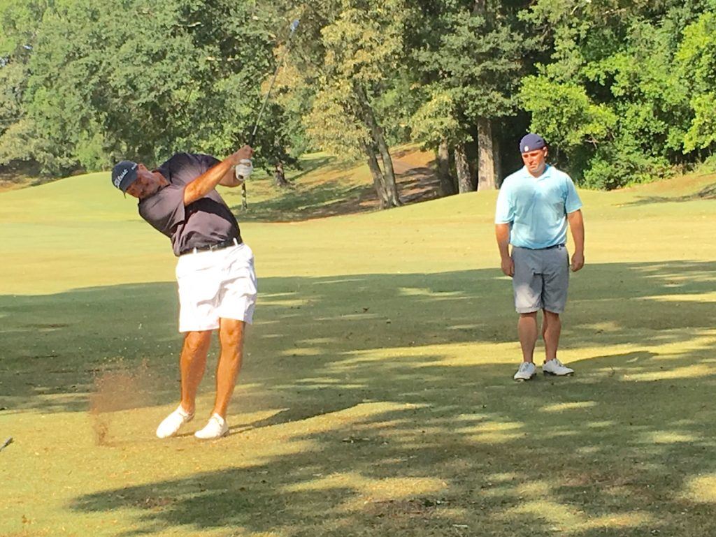 Garrett Burgess (R) watches Gary Wigington hit his approach into the par-5 11th that got the eventual champions to 40-under-par in the tournament.