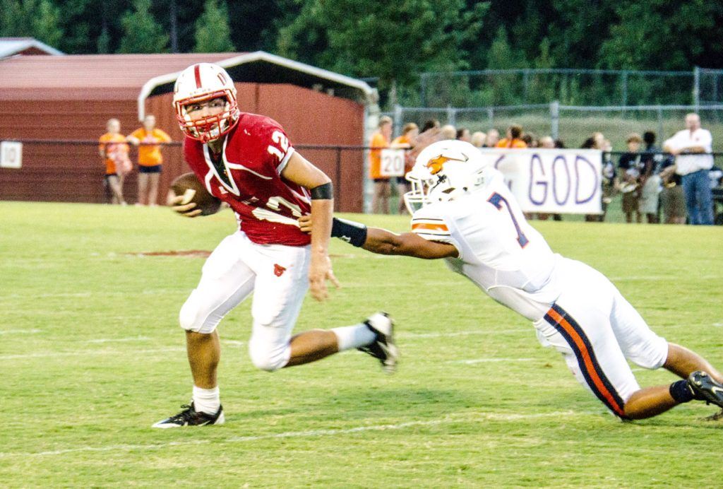 Wadley quarterback Connor Fordham (12) tries to escape the clutches of Woodland's Jordan Herring. (Photo by Christy Fordham)