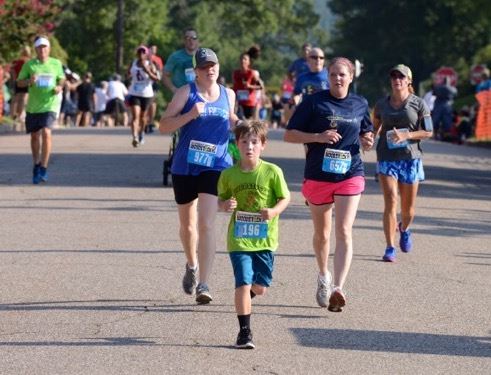 Nine-year-old Pierson Otralek of Anniston (196) races to stay ahead of Mendy Stephens (977) and Kanda Ford (657) at the finish of the Woodstock 5K.