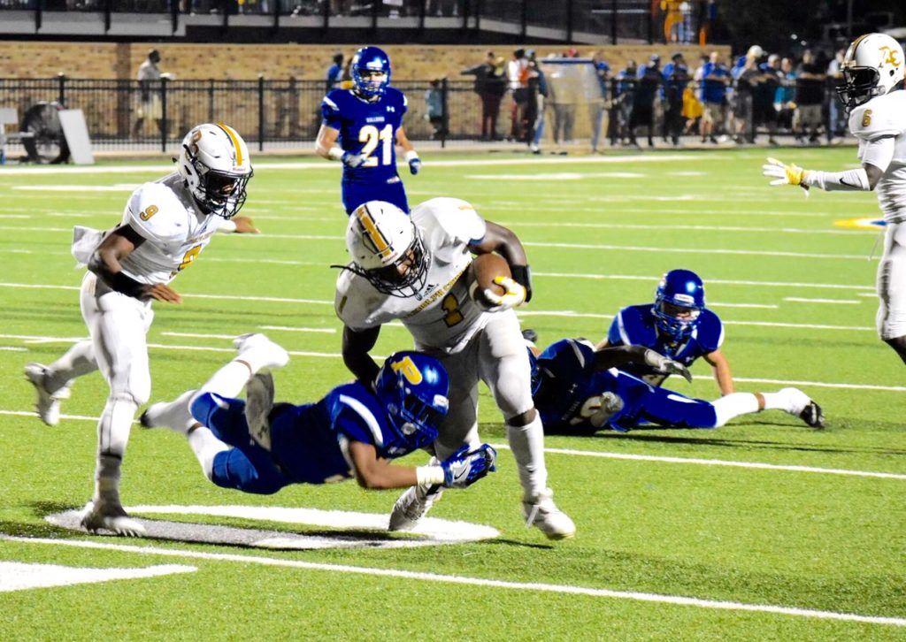 Piedmont's Carl Myers latches onto the leg of Trent Lane in hopes of bringing down the Randolph County ballcarrier before he gets to the end zone. (Photo by Jeremy Wortham/Tiger Den Photography)