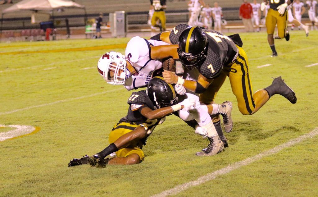 Oxford's Brody Syer (7) and Asante Ferrell (27) sandwich Brewer's Daniel Hyatt in Friday's 44-19 Jackets' victory. (Photo by Kristen Stringer/Krisp Pics Photography)
