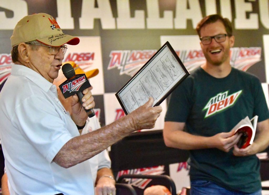 Dale Earnhardt Jr. (R) laughs as Donnie Allison displays a collage of Junior's paychecks when he worked in Allison's shop as a teenager. On the cover, Earnhardt is welcomed as an honorary member of the Alabama Gang by (from left) Donnie Allison, Red Farmer and Bobby Allison. (Photos by B.J. Franklin/GungHo Photos)